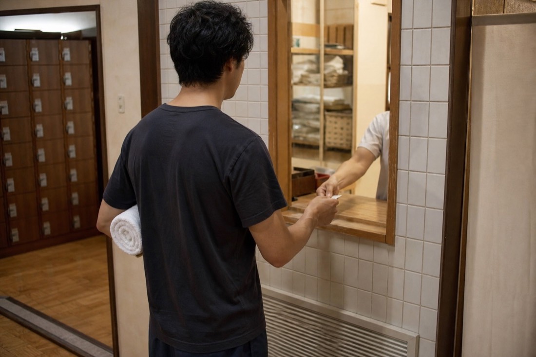 Traveler buying a ticket at a small bath entrance desk in Budapest