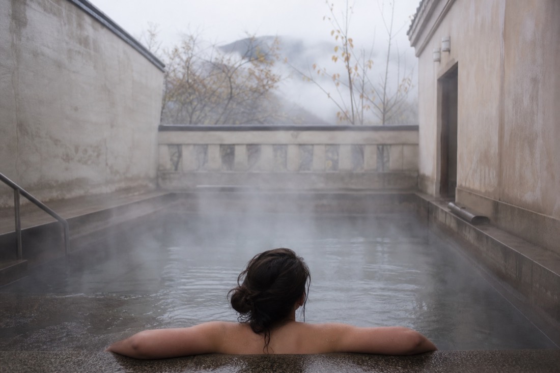 Steam rising from a small warm thermal pool at a quiet Budapest neighborhood bath
