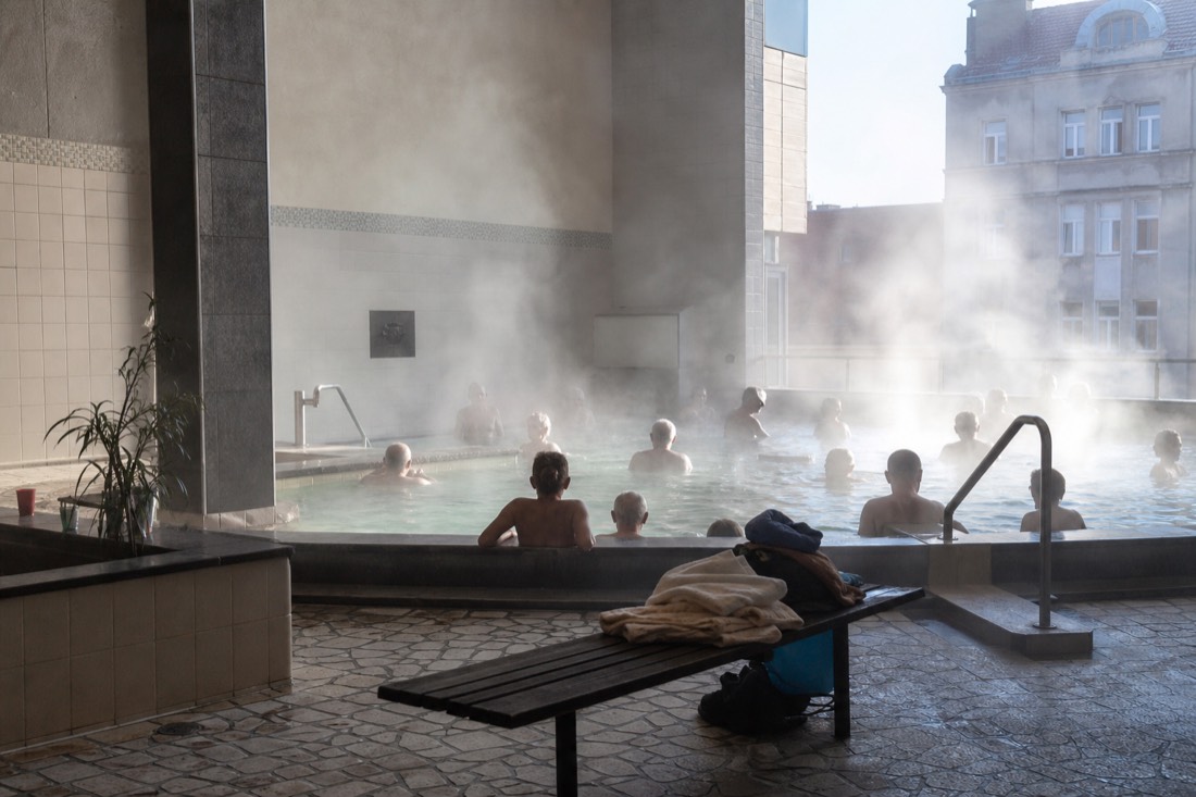Budapest locals relaxing in a small neighborhood thermal pool early in the morning