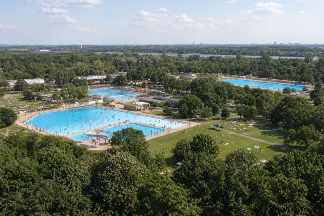 Open-air lido pools surrounded by grass and trees on Margaret Island in Budapest
