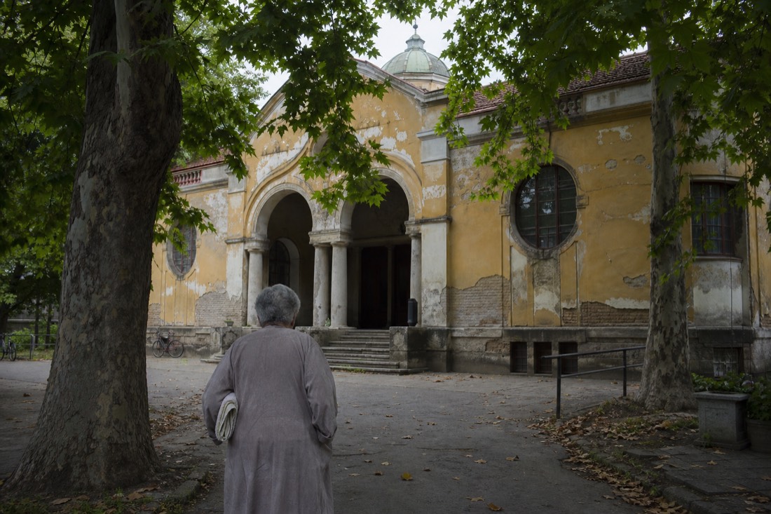 Weathered facade and leafy entrance courtyard of a local Budapest thermal bath on the Buda side