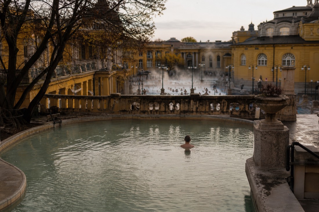 Contrast of a quiet Buda bath courtyard with the grand ornate architecture of a famous Budapest spa