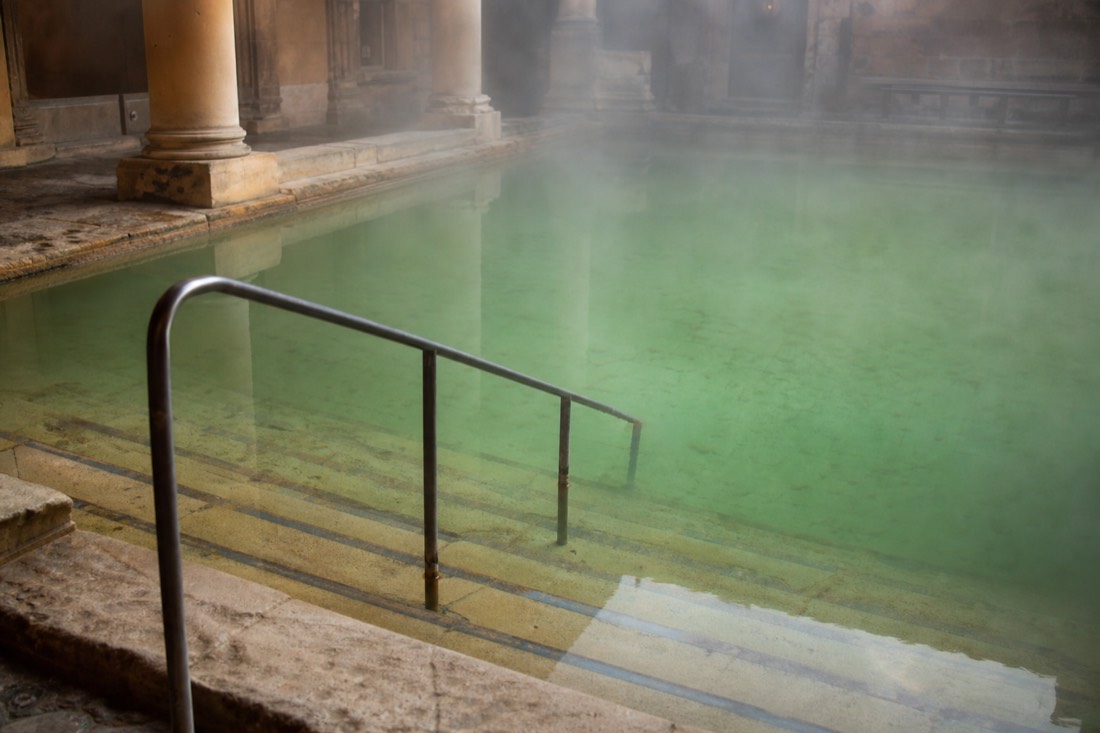 Warm shallow thermal pool with wide steps and handrails at a Budapest bath